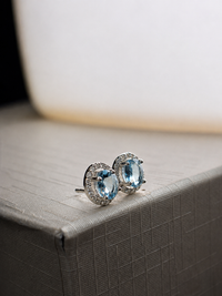 Arete oval de aguamarina con halo de diamantes en oro blanco 14k