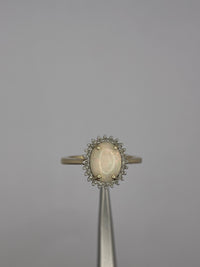 Anillo en oro amarillo y diamantes con ópalo natural