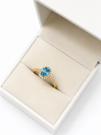 Anillo oval aguamarina con halo de diamantes en oro 14k