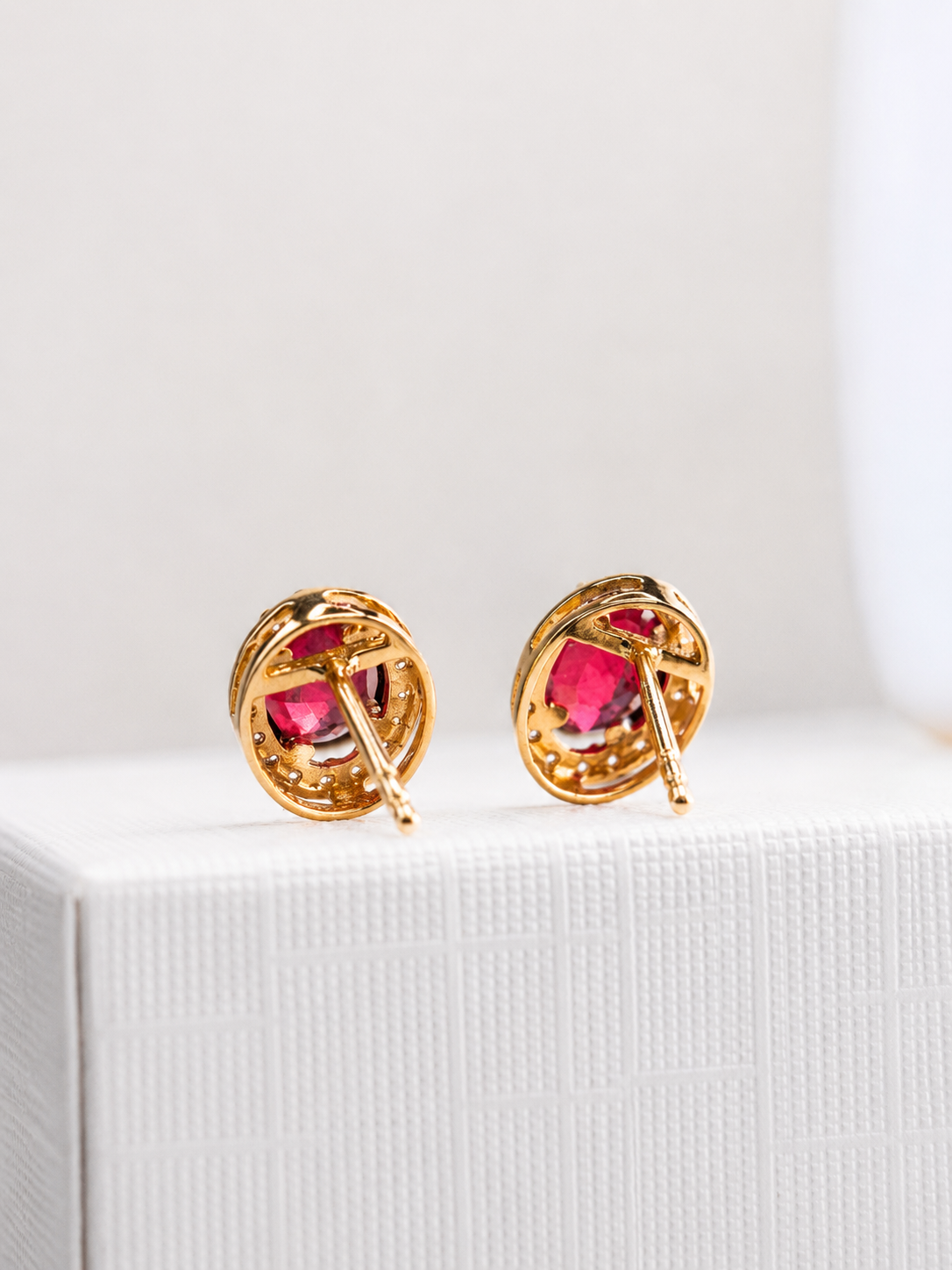 Arete oval de rubí con halo de diamantes en oro 14k