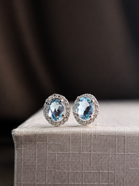 Arete oval de aguamarina con halo de diamantes en oro blanco 14k