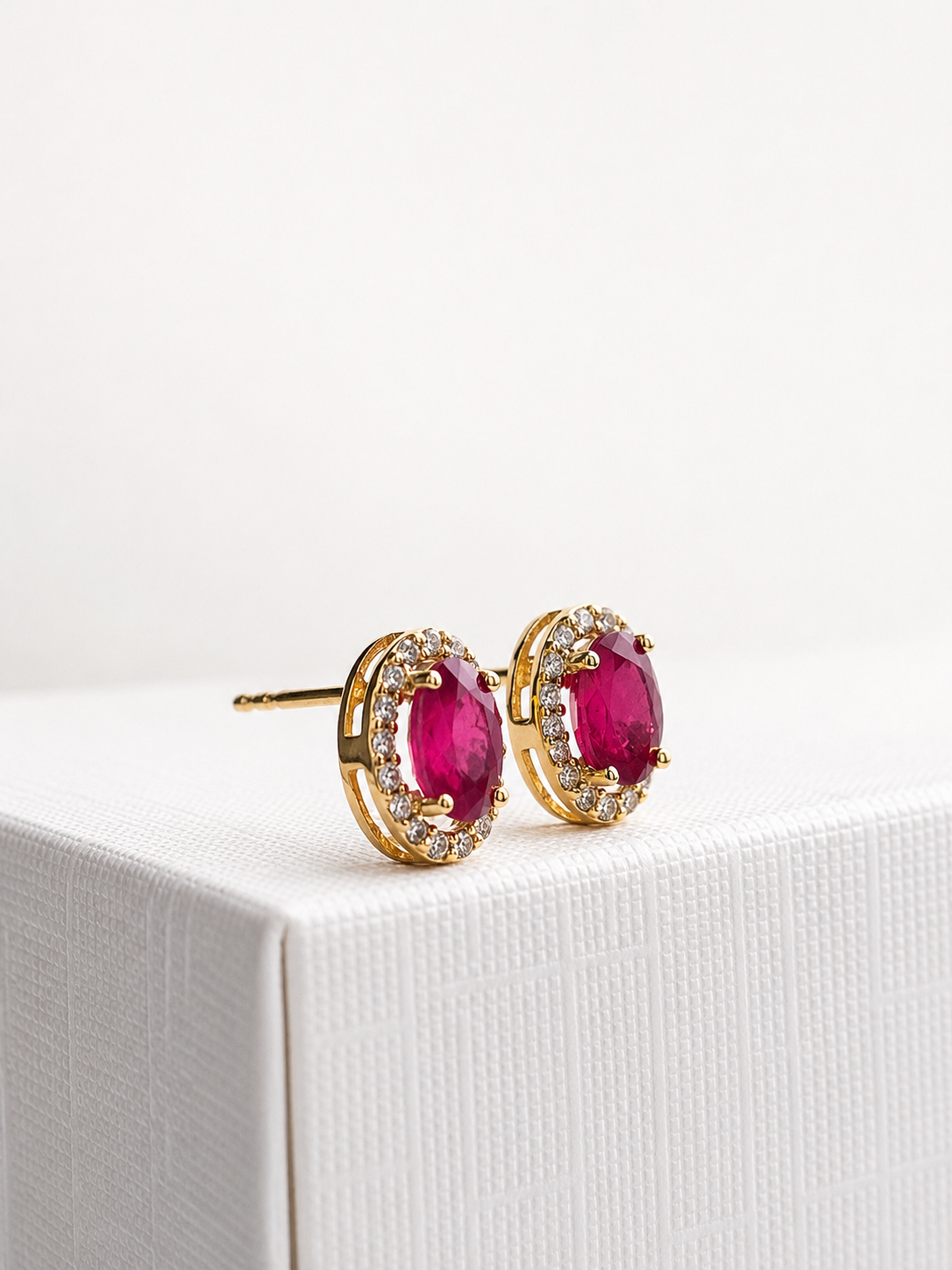 Arete oval de rubí con halo de diamantes en oro 14k